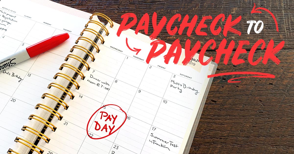 A personal planner showing a calendar with PAYDAY circled on the fifteenth of the month.