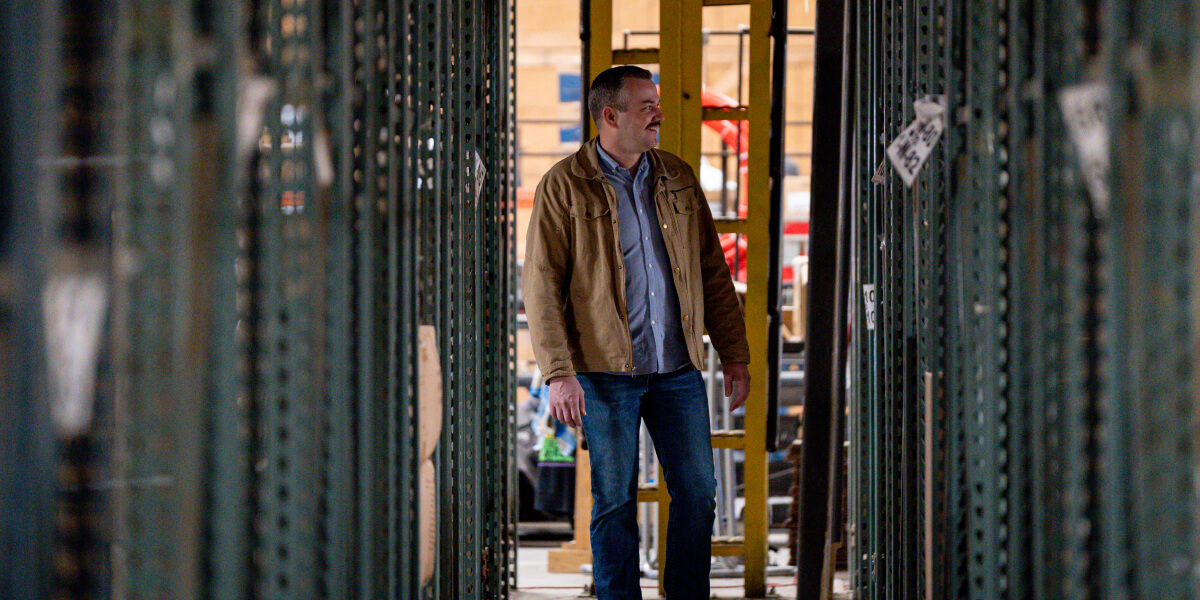 Andy Baker walking through shop smiling