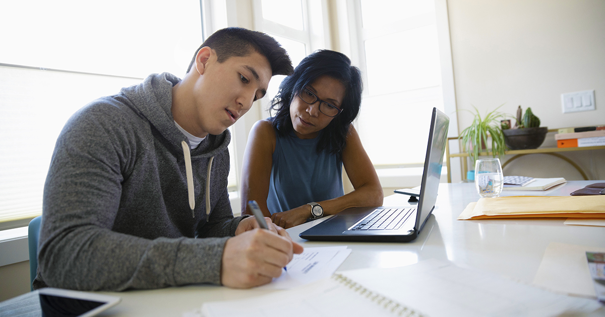 mom and son look over school documents in home