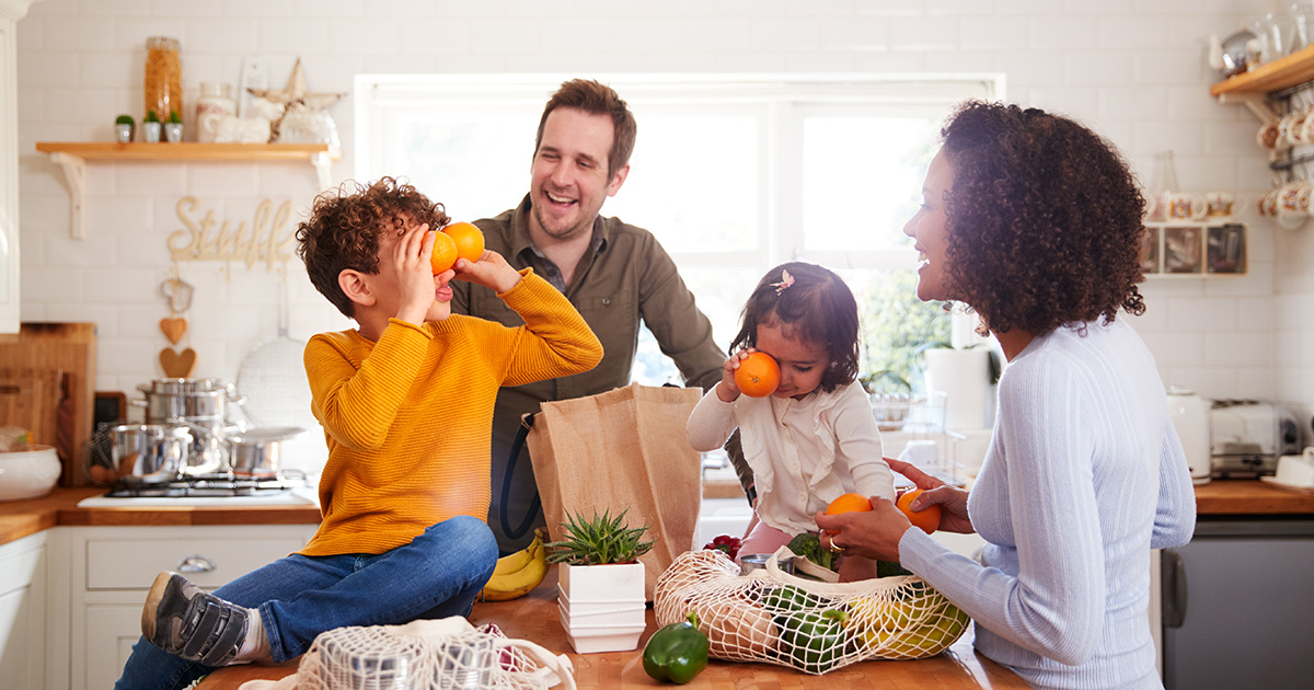 family of four in kitchen goofing around