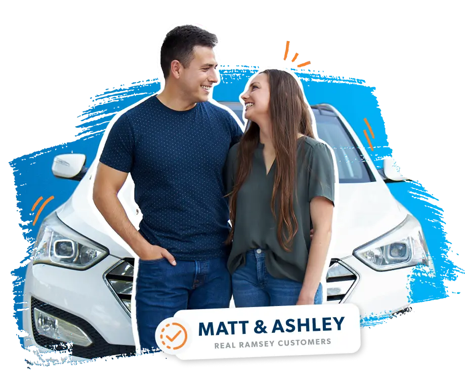 A couple smiling in front of a SUV