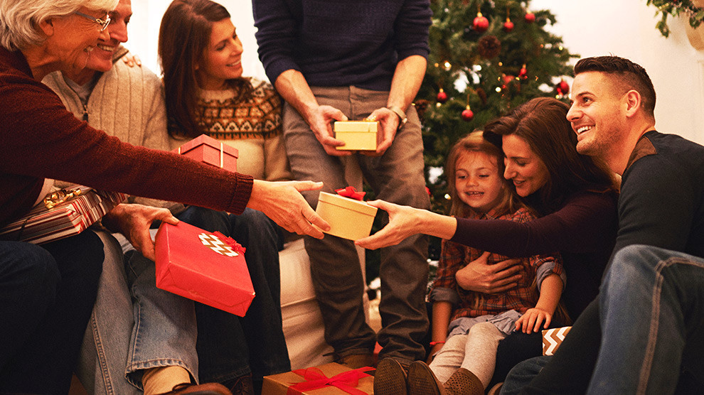A family gathered in a close circle handing out gifts