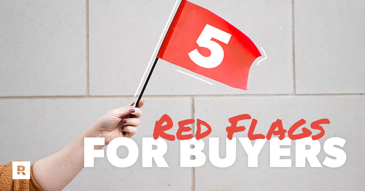 A person holding out a red flag symbolizing the red flags for home inspectors. 