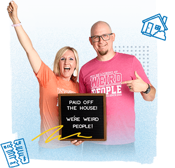 The Graham family holding a letterbox sign that says "Paid Off the House! We're Weird People!"